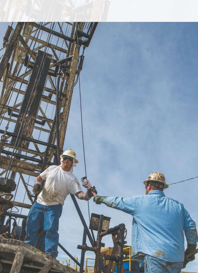 Oil field engineers and workers at a drilling site